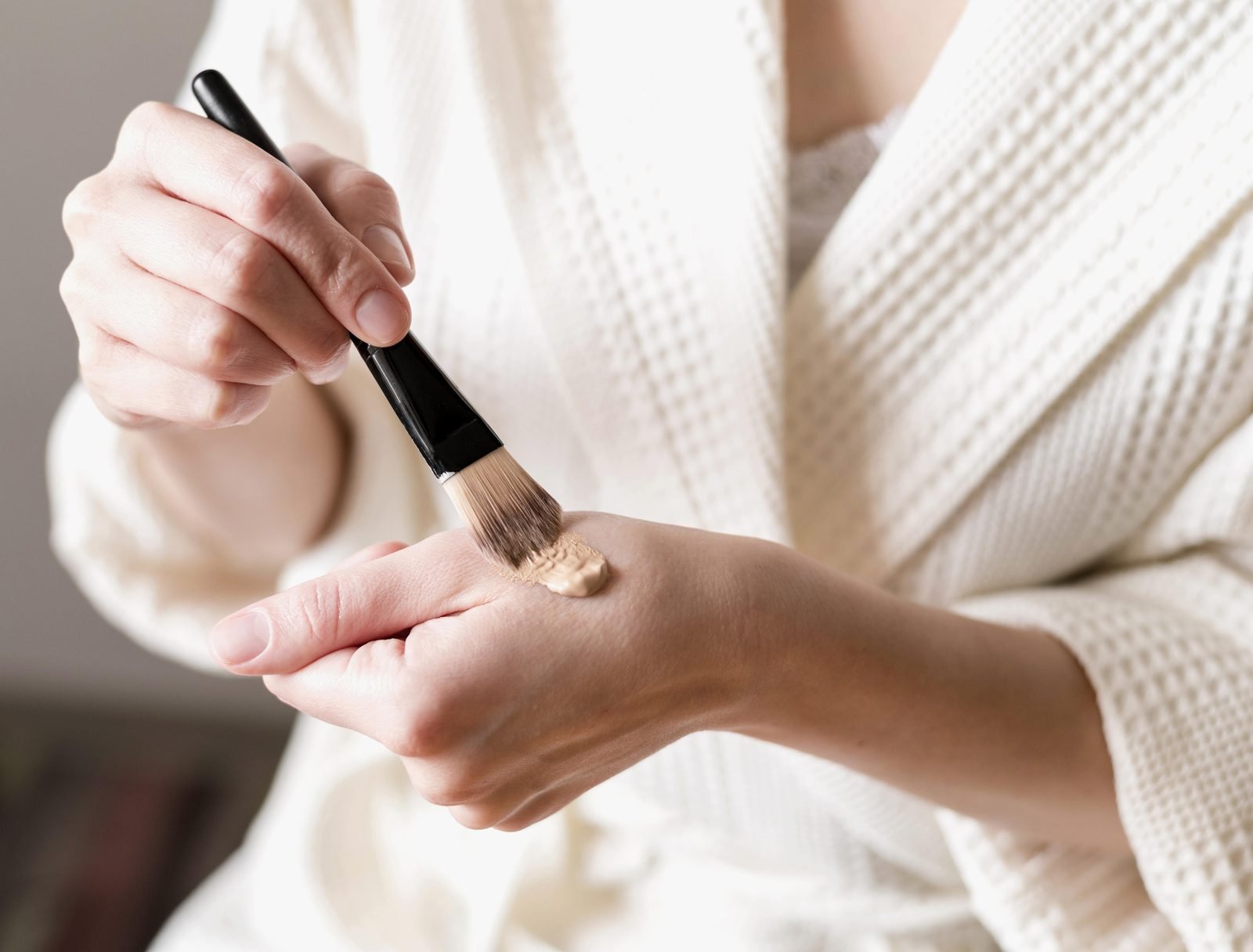 Foundation being applied to hand with a brush