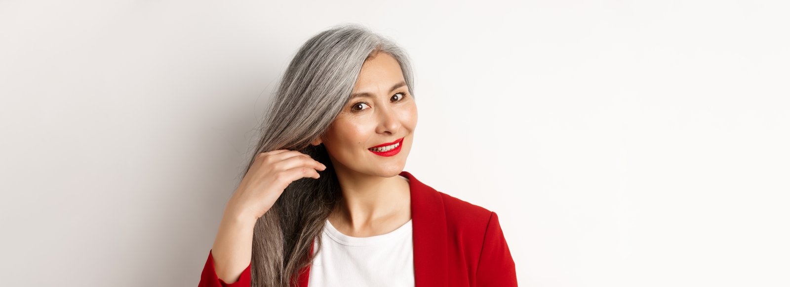 Woman applying root touch-up spray to gray regrowth