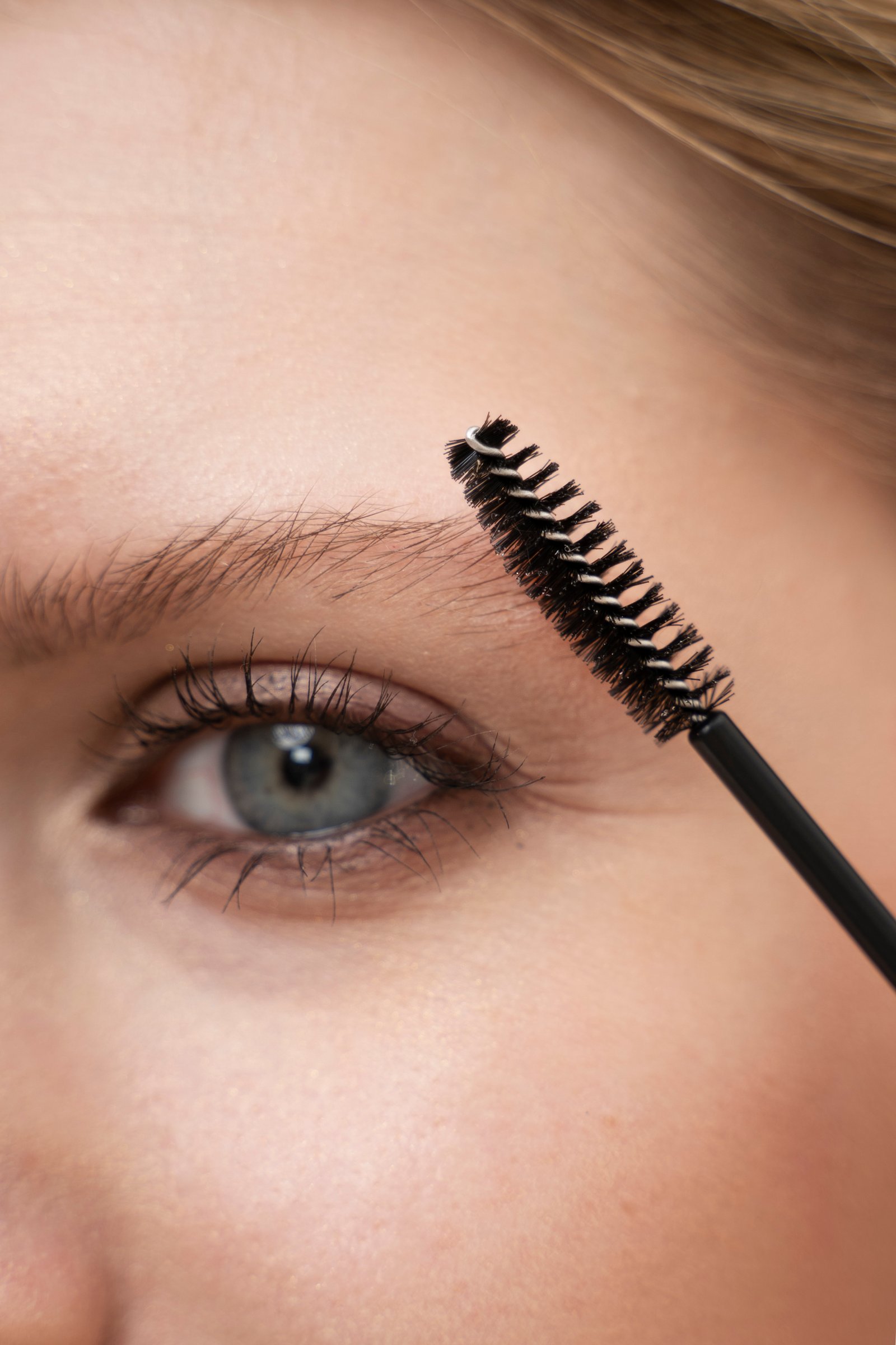 Mascara wand applying volumizing formula to thin, sparse lashes