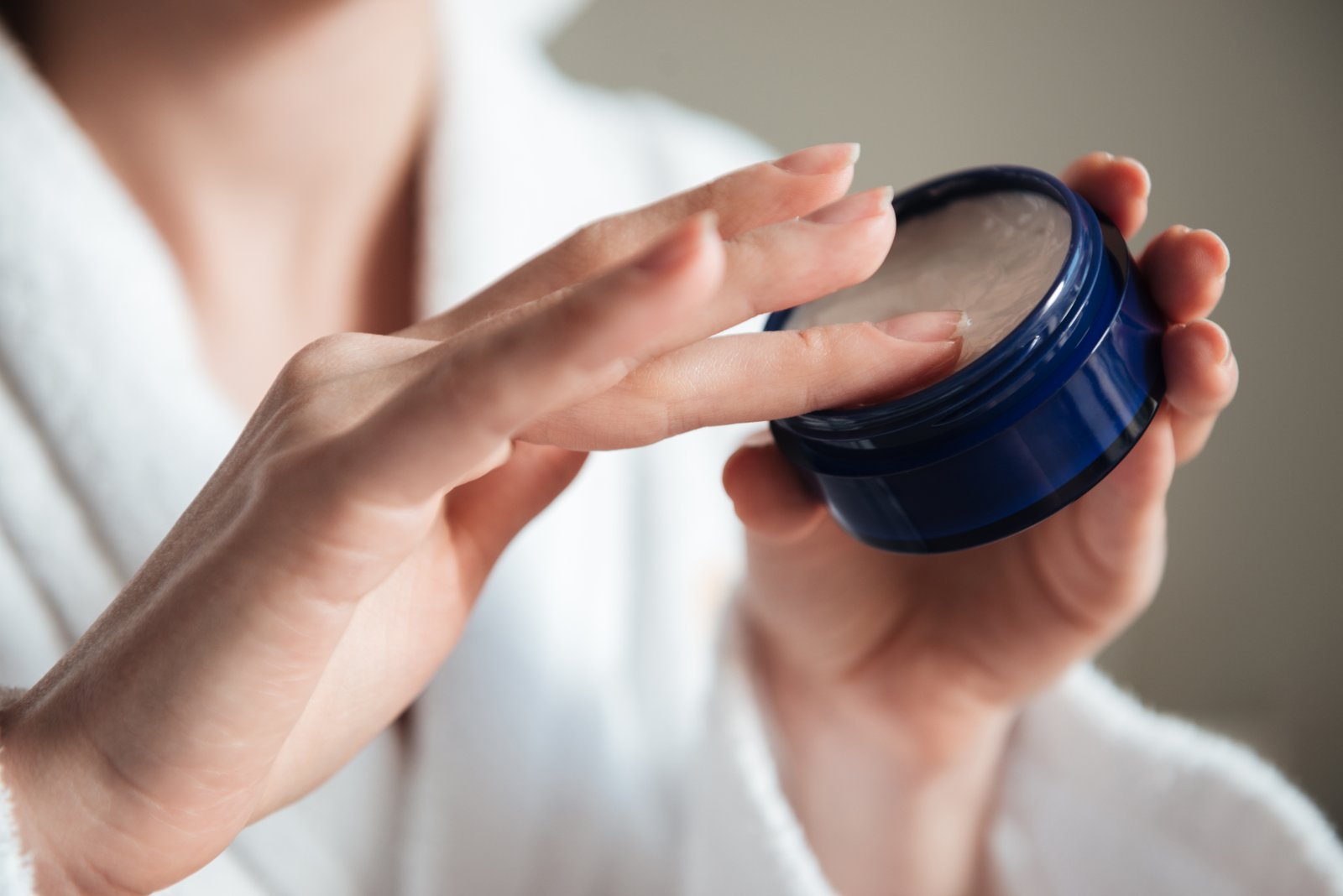 Woman applying face moisturizer