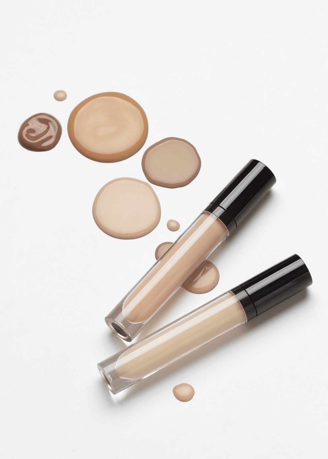 Foundation and concealer swatches in varying shades next to applicator tubes